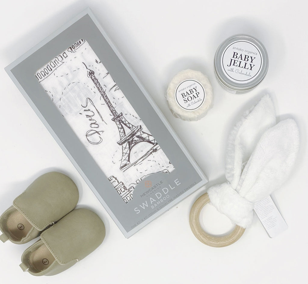 Grey Skies Gift Box Contents Newcastle Classics ~ London, Paris New York Bamboo Swaddle Blanket  Sweet N' Swag ~ Loafer Shoes in Grey (size 2)  Anitako Organics ~ Baby Jelly  Anitako Organics ~ Baby Soap  Newcastle Classics ~ Bunny Wooden Teether (Grey)